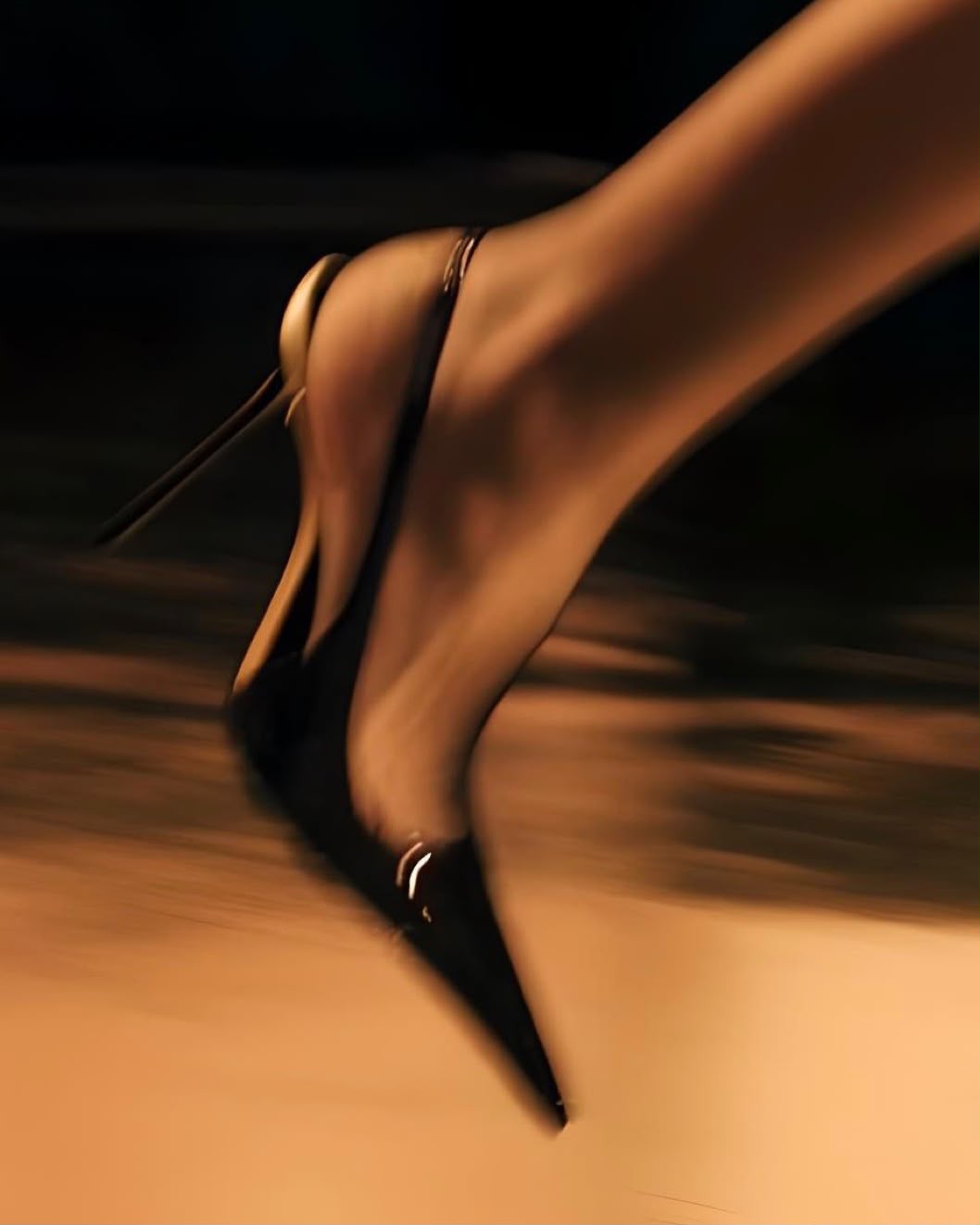 Ein Schritt in schwarzen High Heels, in warmem Licht